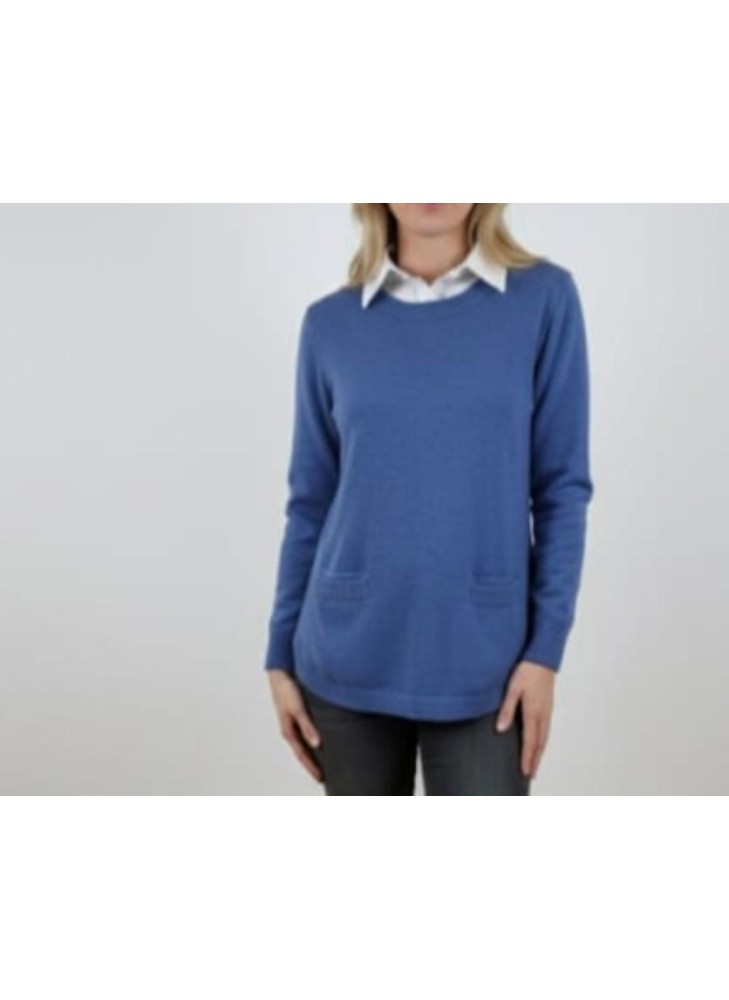 modelo luciendo jersey azul de punto con bolsillos delanteros y cuello de camisa blanca integrado en el jersey