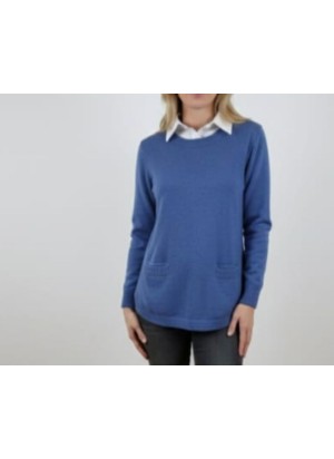 modelo luciendo jersey azul de punto con bolsillos delanteros y cuello de camisa blanca integrado en el jersey