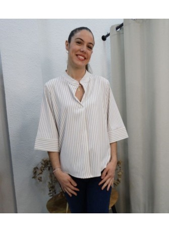 Modelo luciendo blusa de rayas verticales beige y blancas con cuello mao y manga tres cuartos