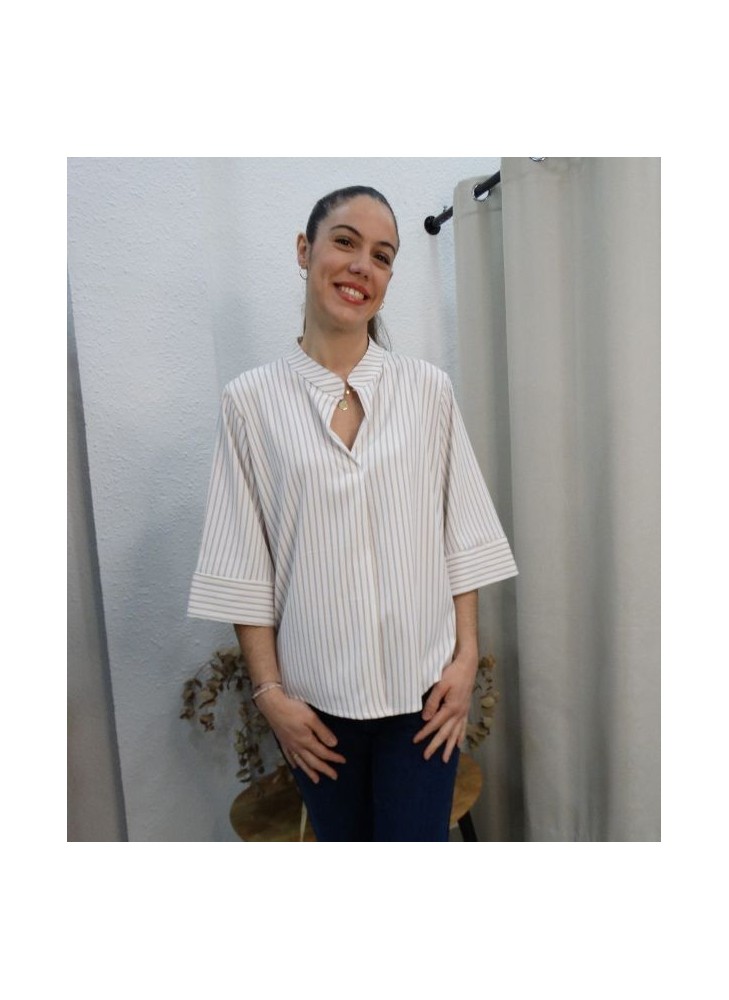 Modelo luciendo blusa de rayas verticales beige y blancas con cuello mao y manga tres cuartos
