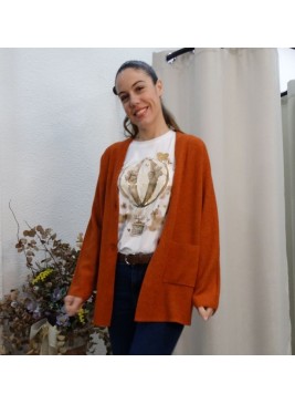 Modelo luciendo rebeca de punto color teja, de corte oversize con bolsillos frontales