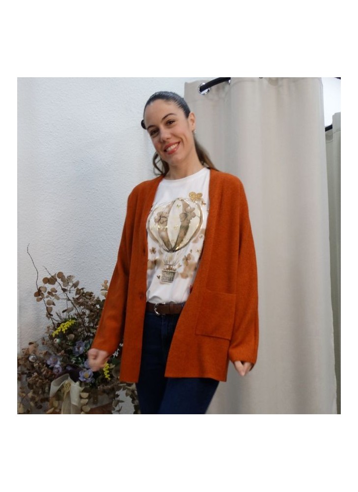 Modelo luciendo rebeca de punto color teja, de corte oversize con bolsillos frontales