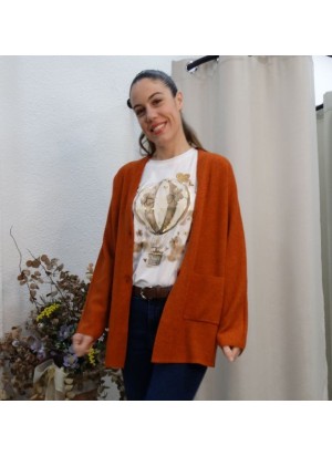 Modelo luciendo rebeca de punto color teja, de corte oversize con bolsillos frontales