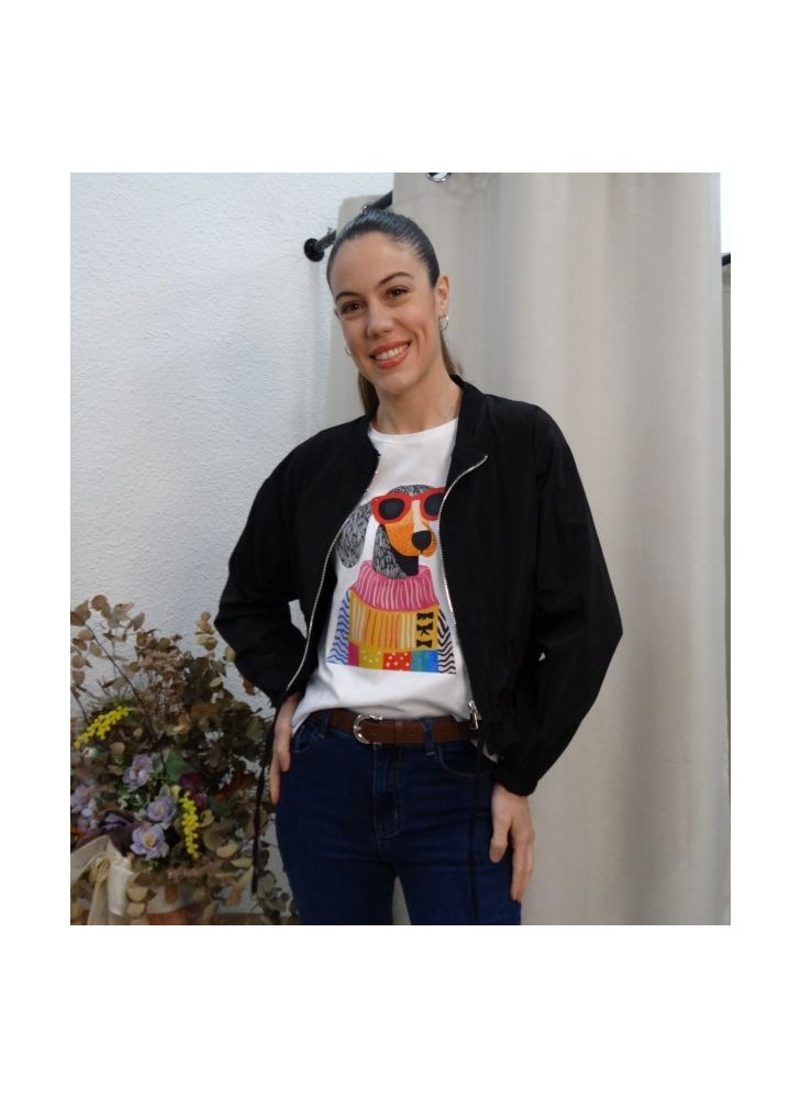 Modelo vistiendo chaqueta bomber negra ligera, con cierre de cremallera plateada, combinada con camiseta gráfica blanca