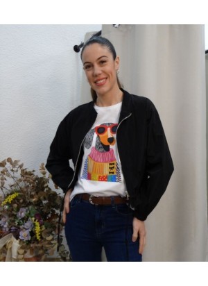 Modelo vistiendo chaqueta bomber negra ligera, con cierre de cremallera plateada, combinada con camiseta gráfica blanca