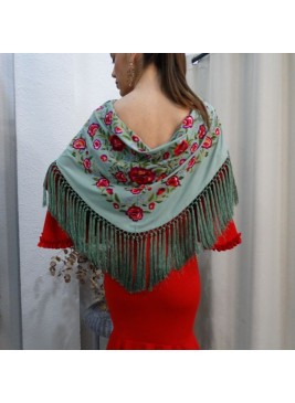 Modelo posando con mantón de flamenca color verde agua, bordado de rosas rojas y flecado a mano