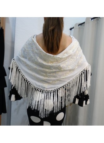 Modelo posando con mantón de flamenca en color blanco marfil bordado a tono y flecado a mano