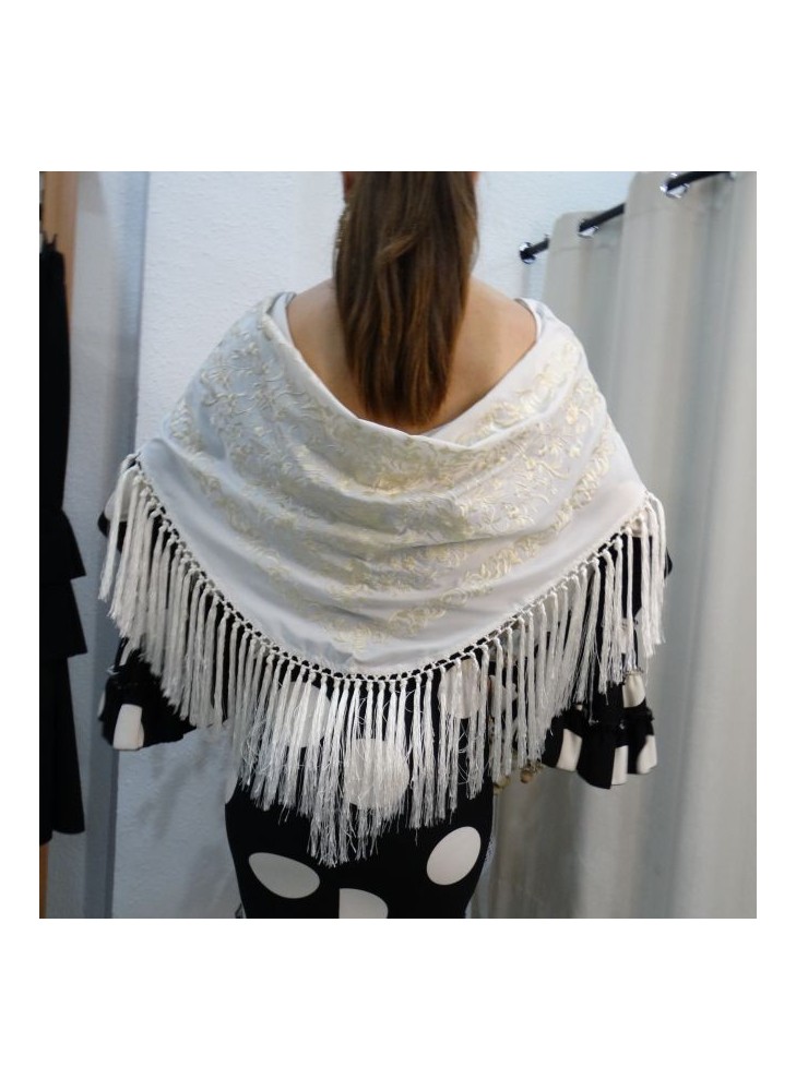 Modelo posando con mantón de flamenca en color blanco marfil bordado a tono y flecado a mano