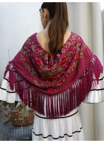 Modelo posando con mantón de flamenca color buganvilla con motivos florales y flecado a mano