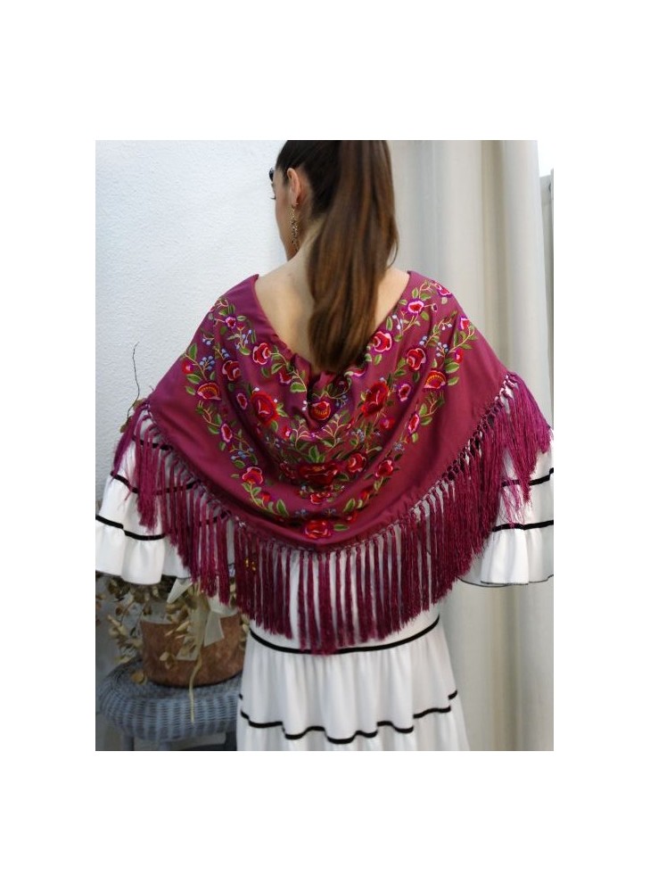Modelo posando con mantón de flamenca color buganvilla con motivos florales y flecado a mano