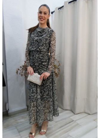 Mujer luciendo vestido largo de fiesta con estampado botánico en blanco y negro, manga de tul y detalles drapeados
