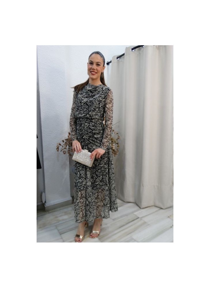 Mujer luciendo vestido largo de fiesta con estampado botánico en blanco y negro, manga de tul y detalles drapeados
