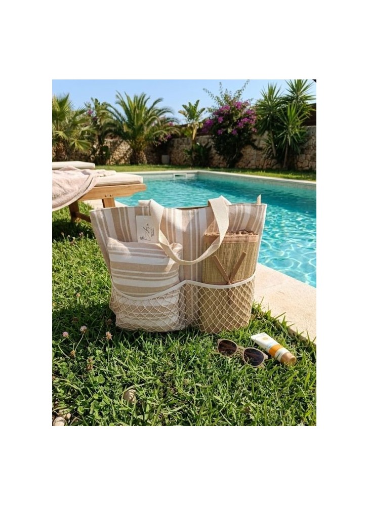 Bolso de playa a rayas beige y blanco con bolsillos de malla exteriores, incluye un cojín y esterilla de playa.