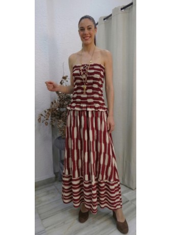 Modelo vistiendo vestido largo estilo bohemio en color burdeos y crema, con cuerpo estilo ( smocked ) sin tirantes