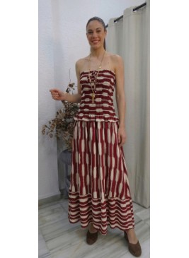 Modelo vistiendo vestido largo estilo bohemio en color burdeos y crema, con cuerpo estilo ( smocked ) sin tirantes